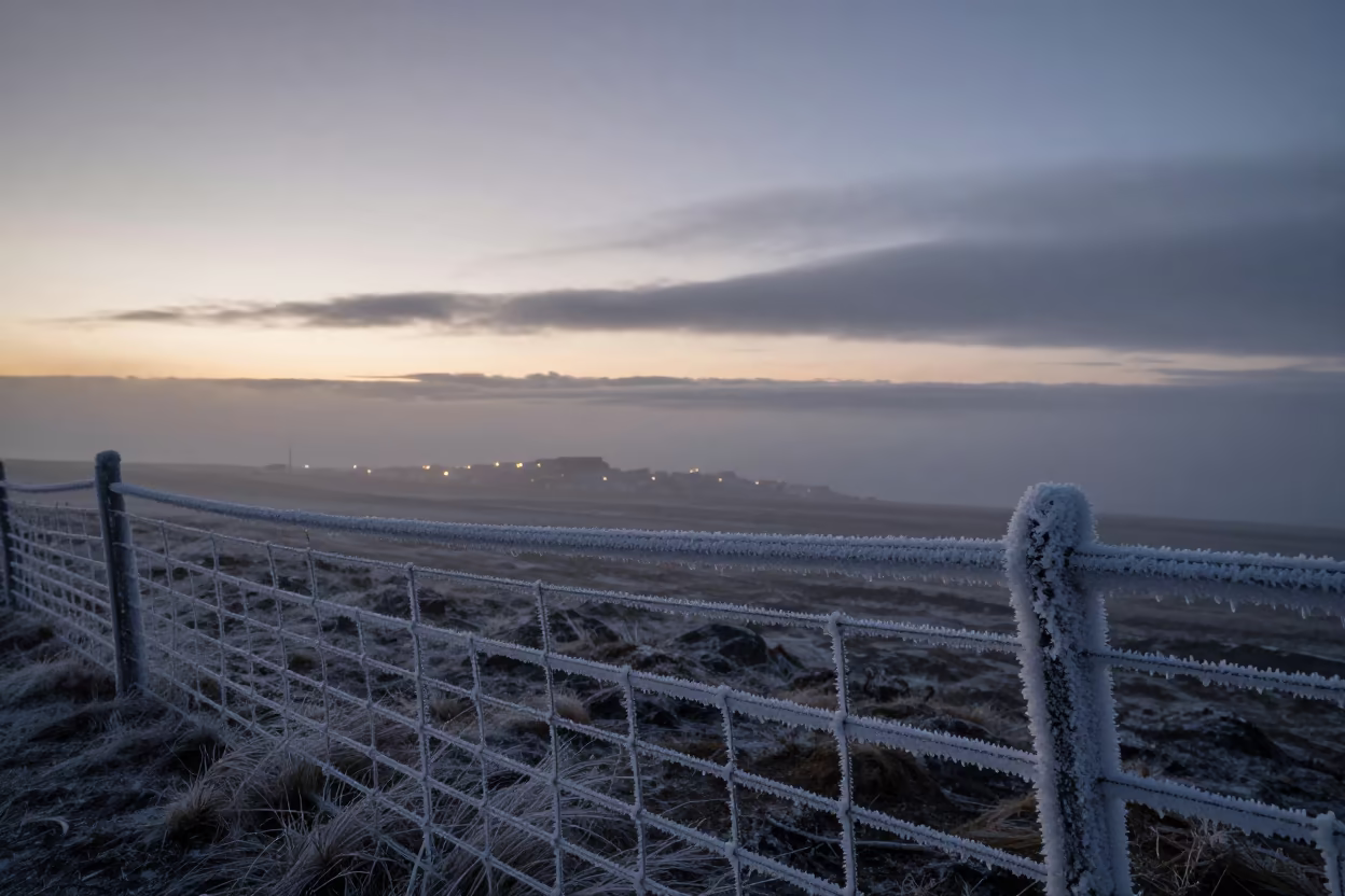 Rime Ice Coated Fence Under Twilight Clouds in beneath fast-moving cloud bands in Iceland