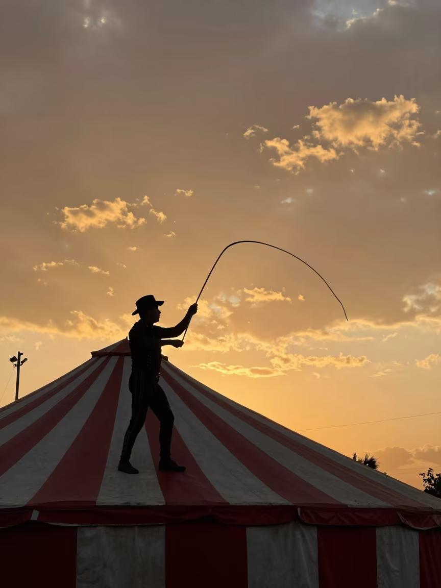 Ringmaster Silhouette Under Striped Big Top in at a street corner busking spot in Veracruz