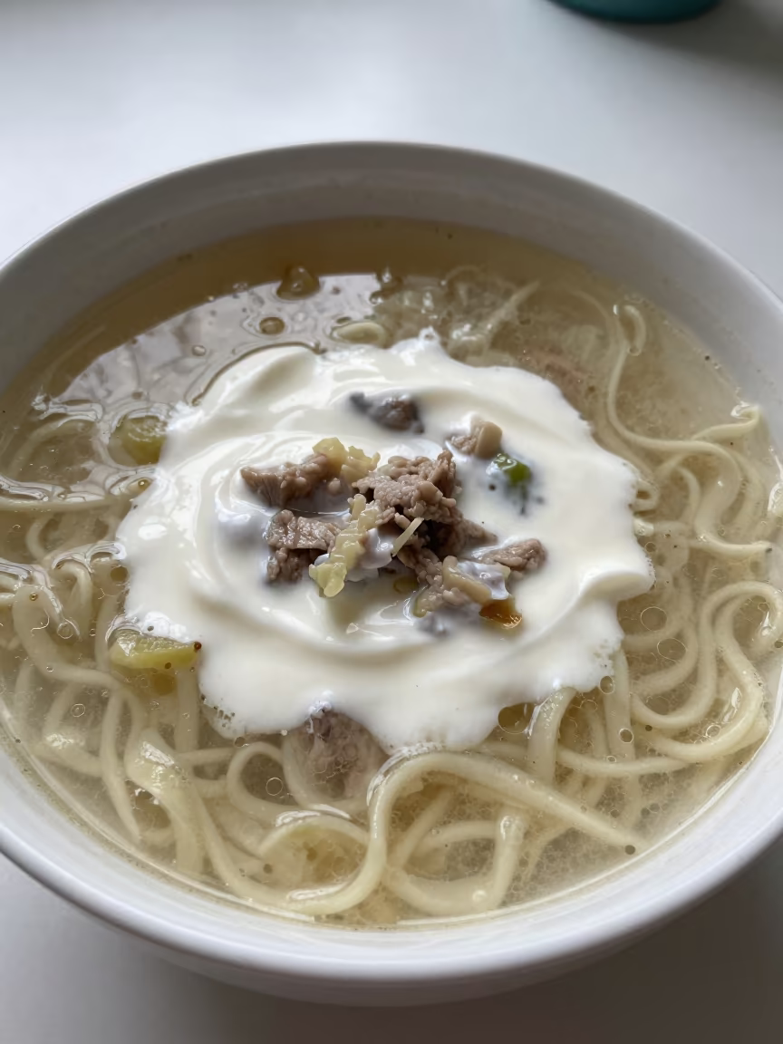 Romanian Ciorba Soup with Sour Cream at Bonn Noodle Counter in at a noodle counter in Bonn