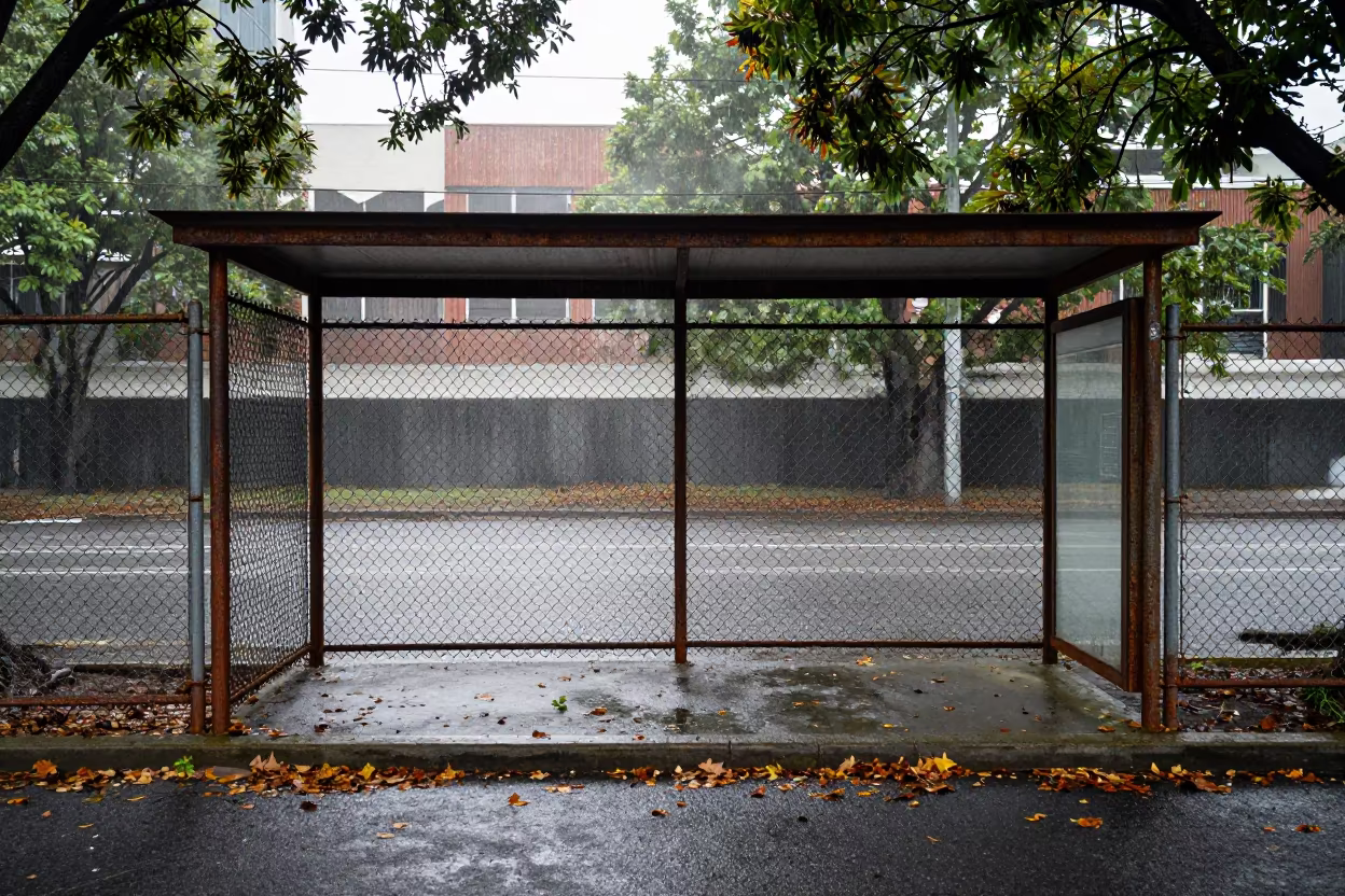 Rusted Fence Beside Brisbane Bus Shelter in Autumn Rain in beside a steamed-up bus shelter in Brisbane