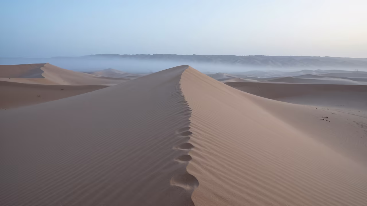 Sahara Dune Crest Misty Dawn Light in from a ridge above layered foothills in Grenada