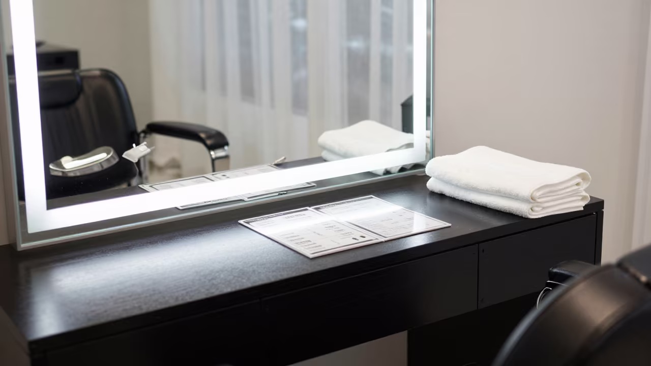 Salon Chair and Towels Under White LED Light in at a barber station beneath mirror bulbs in Changchun