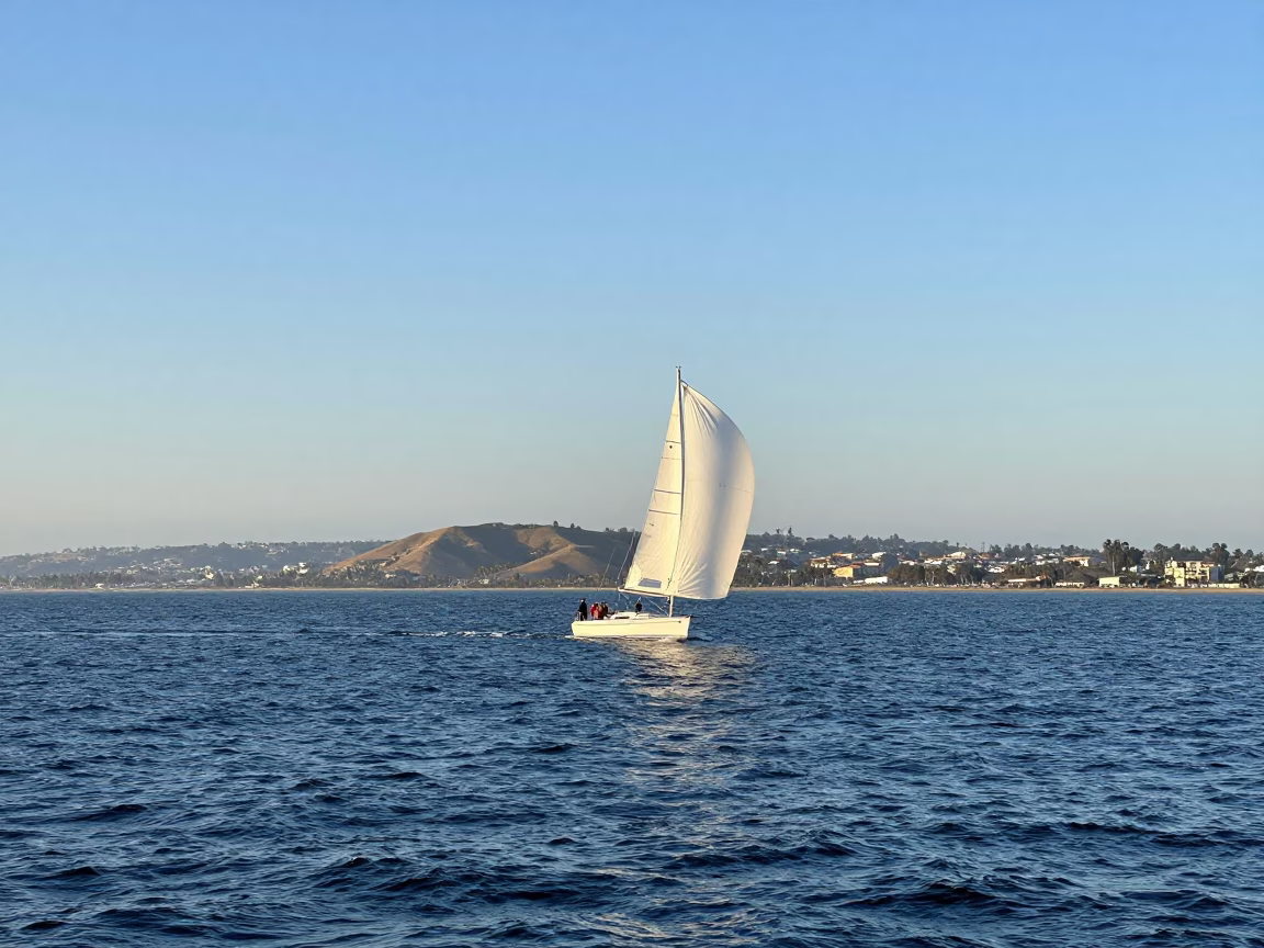 San Diego Bay Sunset Sailboat with Spinnaker and Coastal Hillside Architecture in in San Diego, California, United States