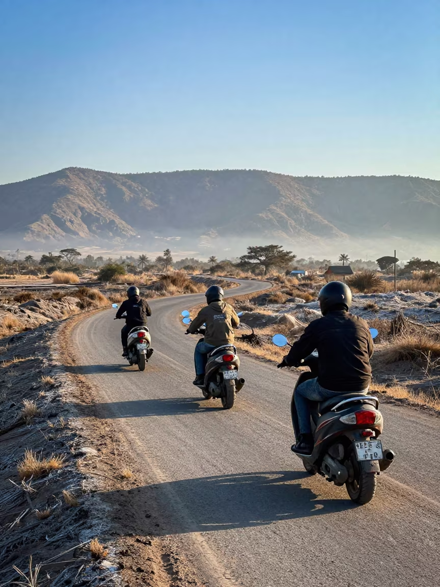 Scooter Convoy Crossing Marsh Causeway in Evening Haze in along a switchback approach near Kano