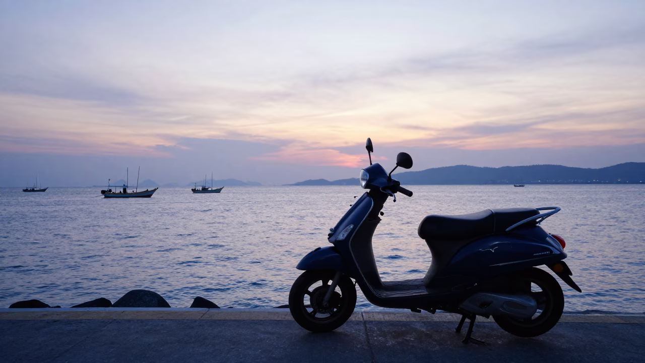 Scooter parked on Phuket harbor promenade at sunset with glass bottles in in Phuket, Thailand