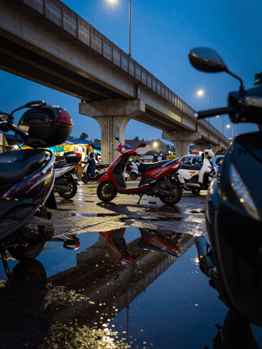 Scooter Reflections in Kampala Night Market Puddle in under an elevated train line in Kampala