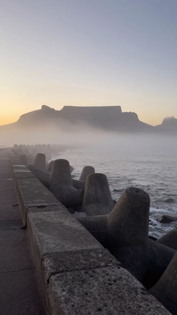 Sea fog crawling over Cape Town breakwater at first light dawn in in Cape Town, South Africa