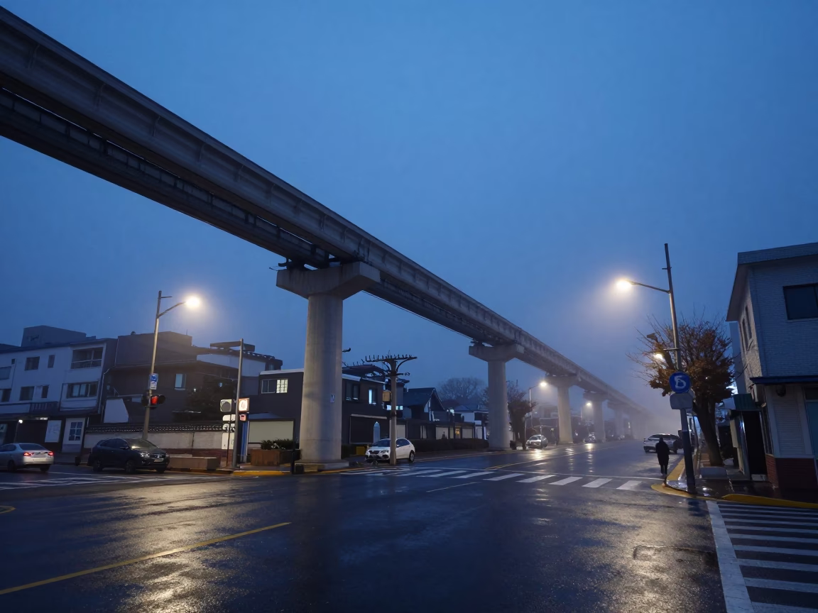 Seoul South Korea pre-dawn monorail tracks above wet asphalt street intersection in in Seoul, South Korea