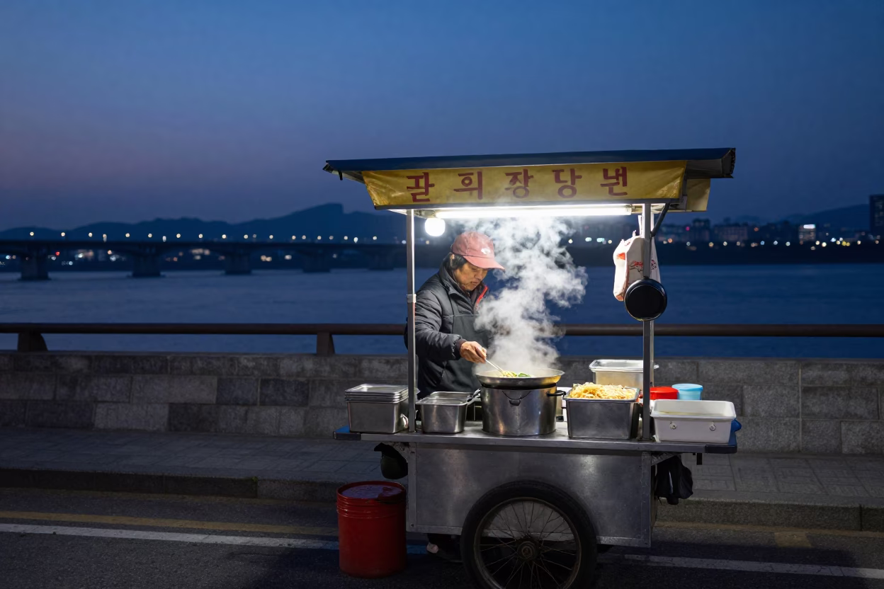 Seoul Street Food Vendor at Dawn with Steaming Noodle Bowls and Wooden Utensils in in Seoul, South Korea