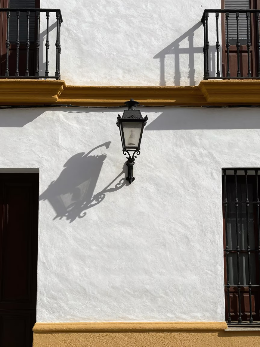 Seville Spain noon sunlight on historic building facade with wall sconce and mineral deposits in in Seville, Spain