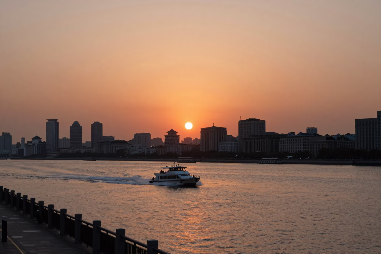 Shanghai Huangpu River Promenade at Sunset with Speedboat Wake and Urban Skyline in in Shanghai, China
