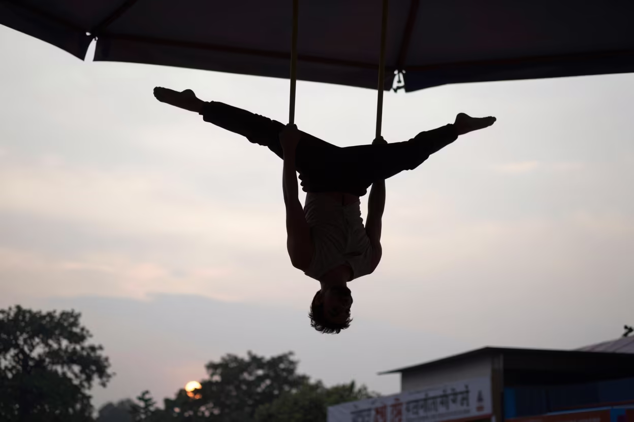 Silhouetted Acrobat Under Circus Tent in Pune in at a street corner busking spot in Pune