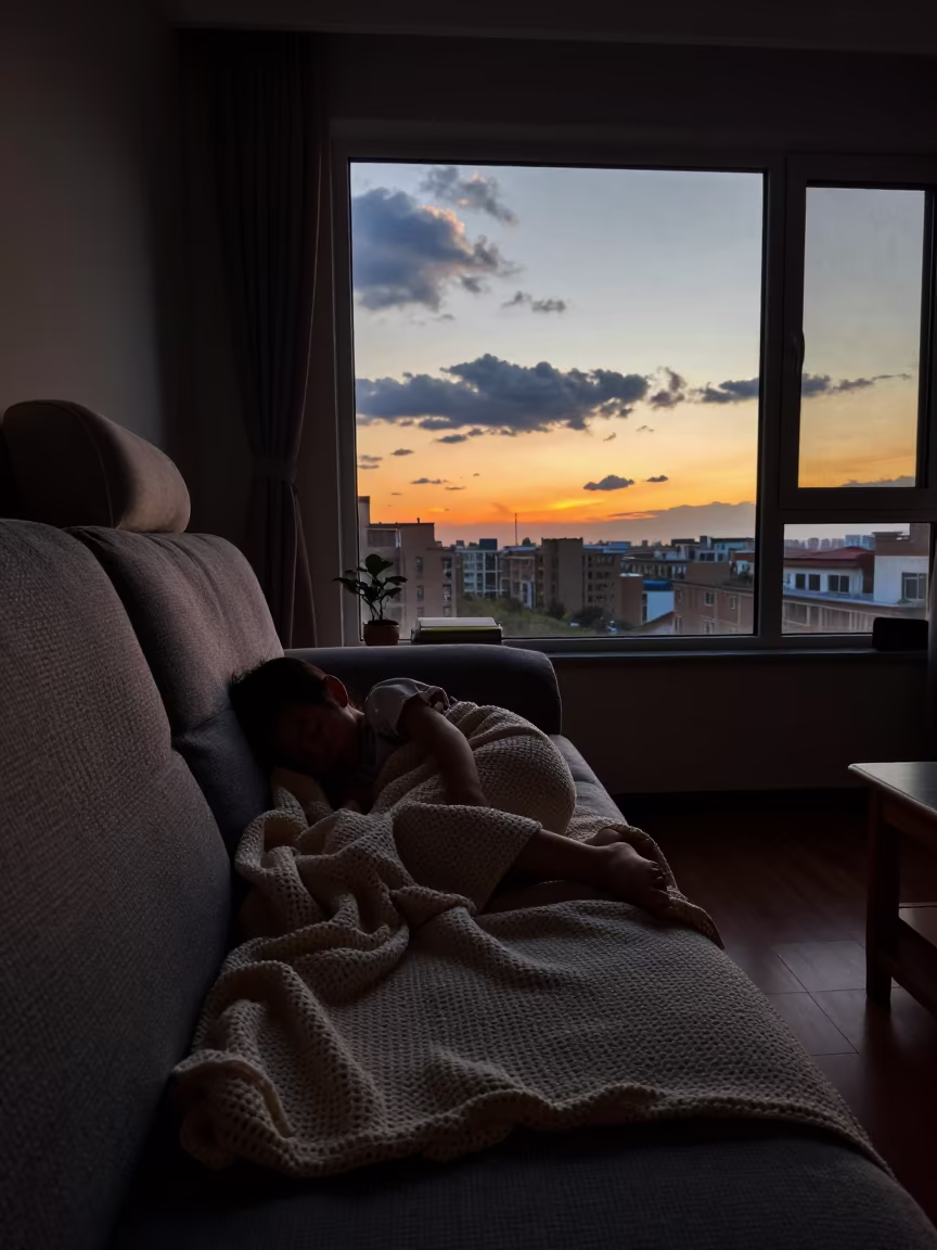 Silhouetted Child Sleeping on Sofa at Beijing Sunset in in Beijing