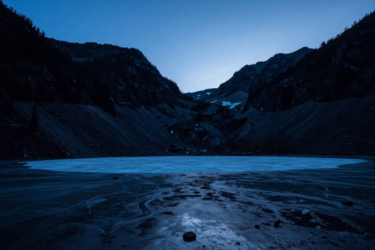 Silhouetted Cirque and Frozen Tarn in Blue Hour in across a floodplain after rain in British Columbia