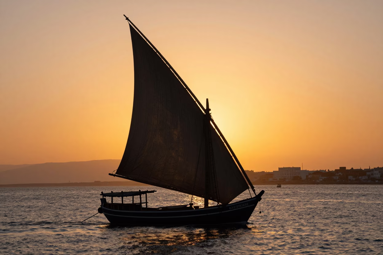 Silhouetted Dhow with Lateen Sail Against Sunset Sky in Casablanca Morocco Harbor in in Casablanca, Morocco