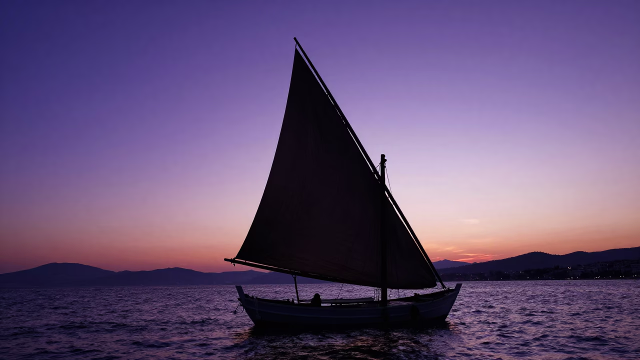 Silhouetted Dhow with Lateen Sail Against Sunset Sky in Izmir Turkey Harbor in in Izmir, Turkey