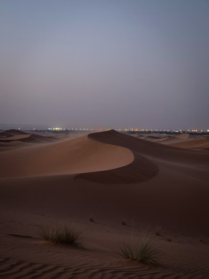 Silhouetted Dune Island Against Dubai City Lights in across a wide valley floor in United Arab Emirates
