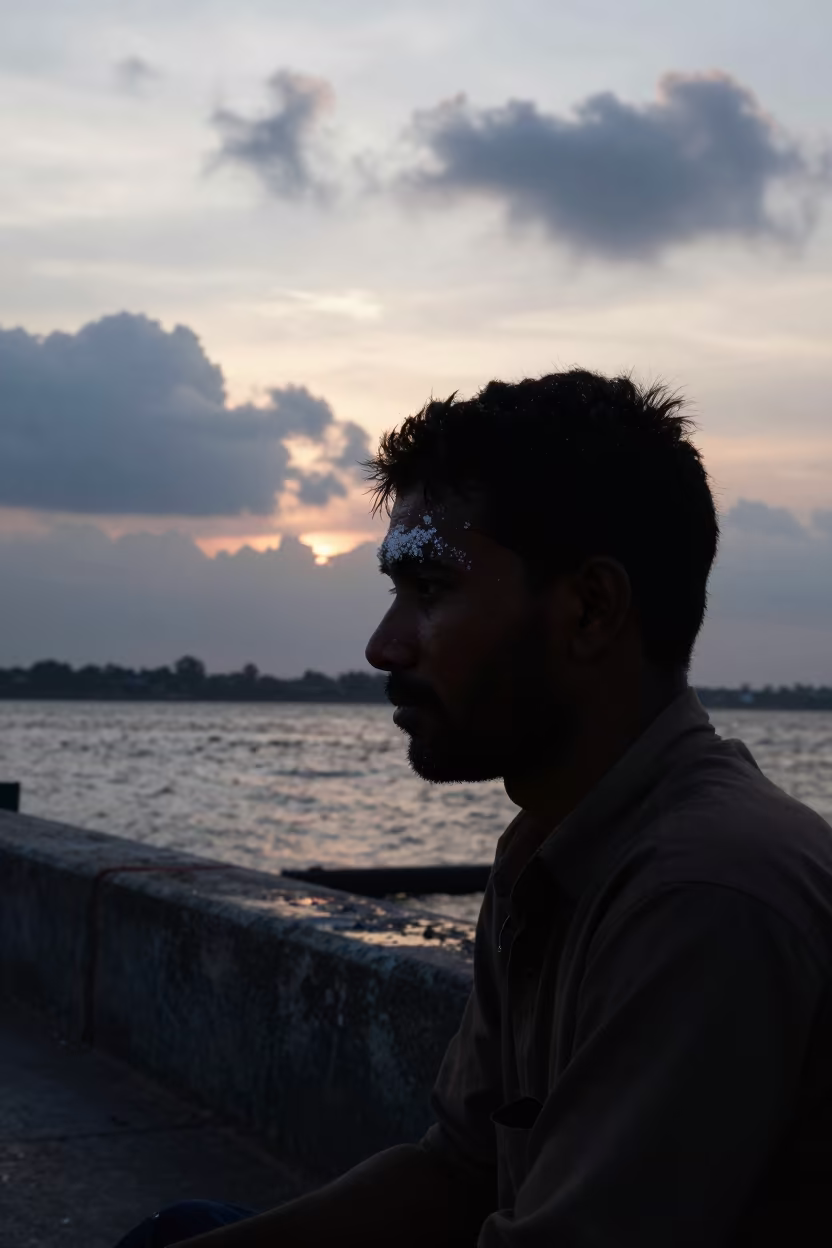 Silhouetted Fishmonger at Guwahati Harbor Sunset in beside a harbor wall near Guwahati