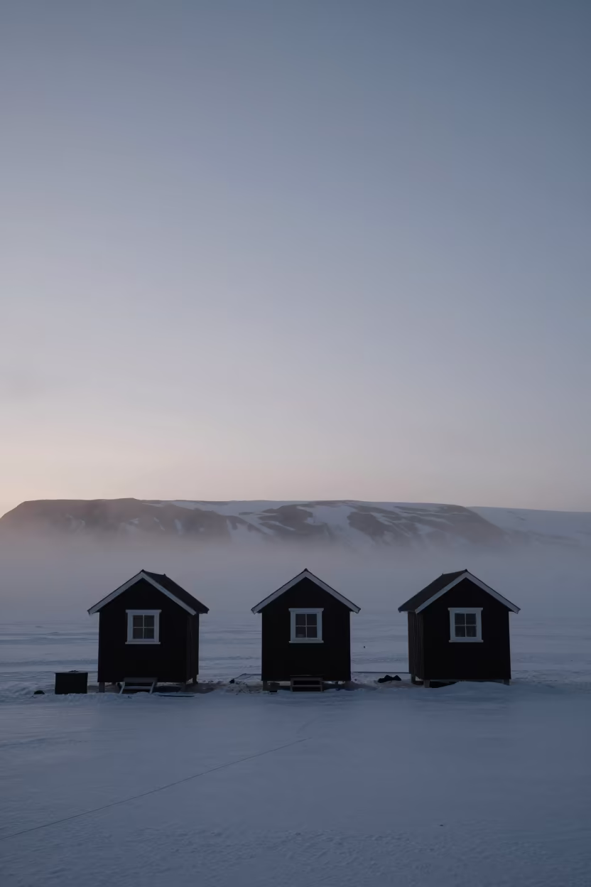 Silhouetted Ice Fishing Shanties Misty Dawn in across a floodplain after rain near Reykjavik