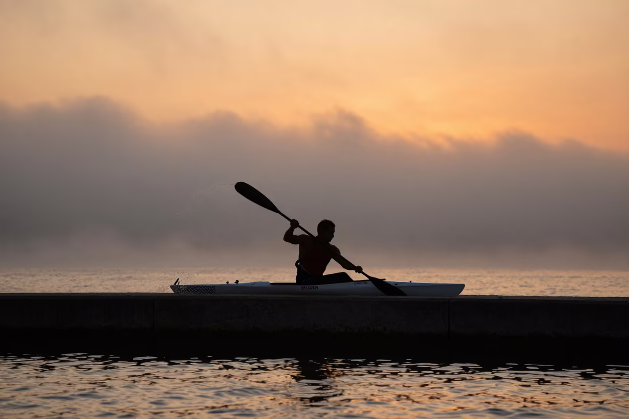 Silhouetted Kayaker in Coastal Fog at Sunset in along a beach near Zagazig