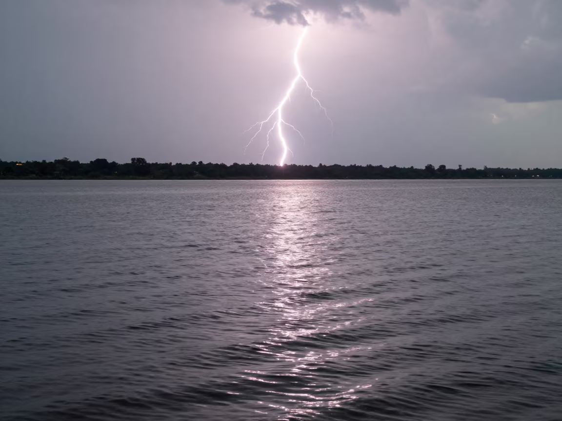 Silhouetted Lightning Over Rippled Lake Myanmar in over a horizon of stacked thunderheads in Myanmar