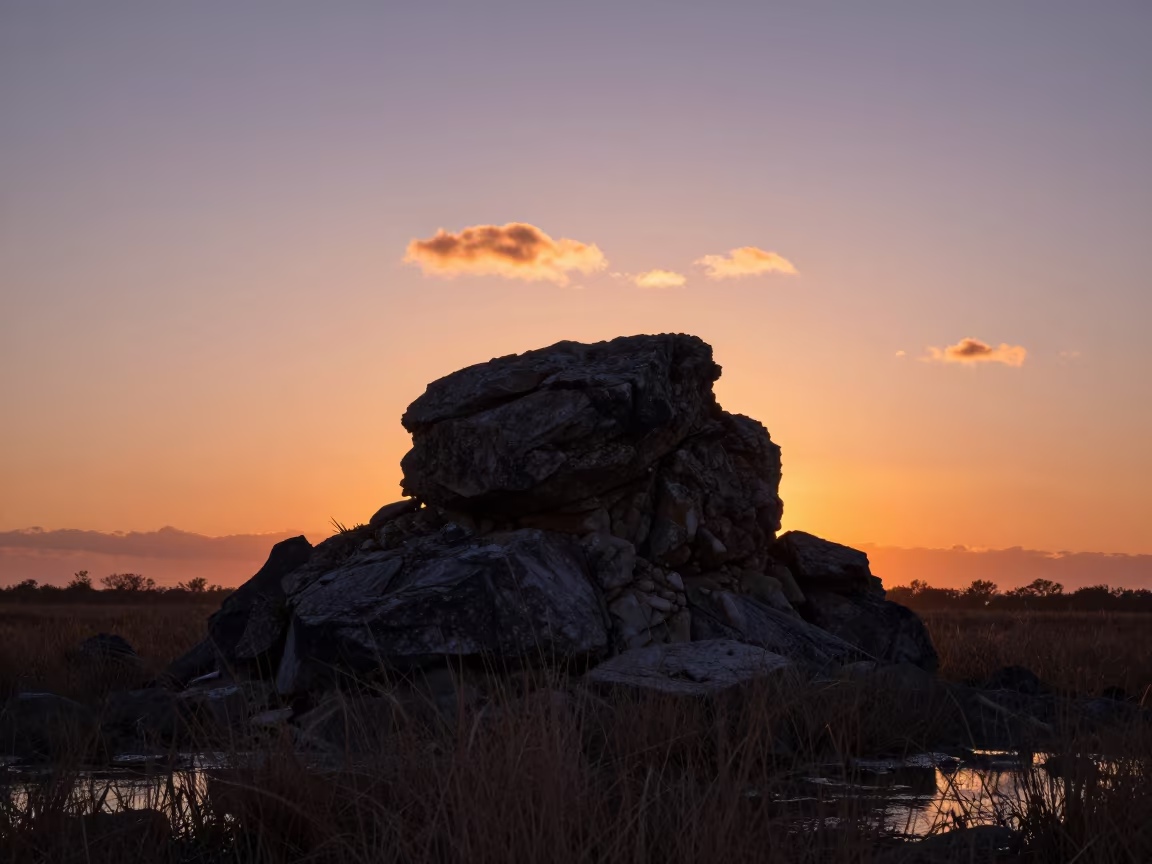 Silhouetted Sea Stack Against Sunset Florida Sky in from a ridge above layered foothills in Florida