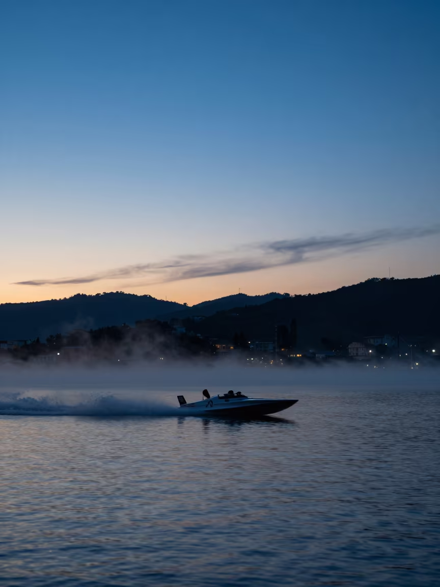 Silhouetted Speedboat Racing Blue Hour Lake in beside a fogbound harbor mouth near Siena