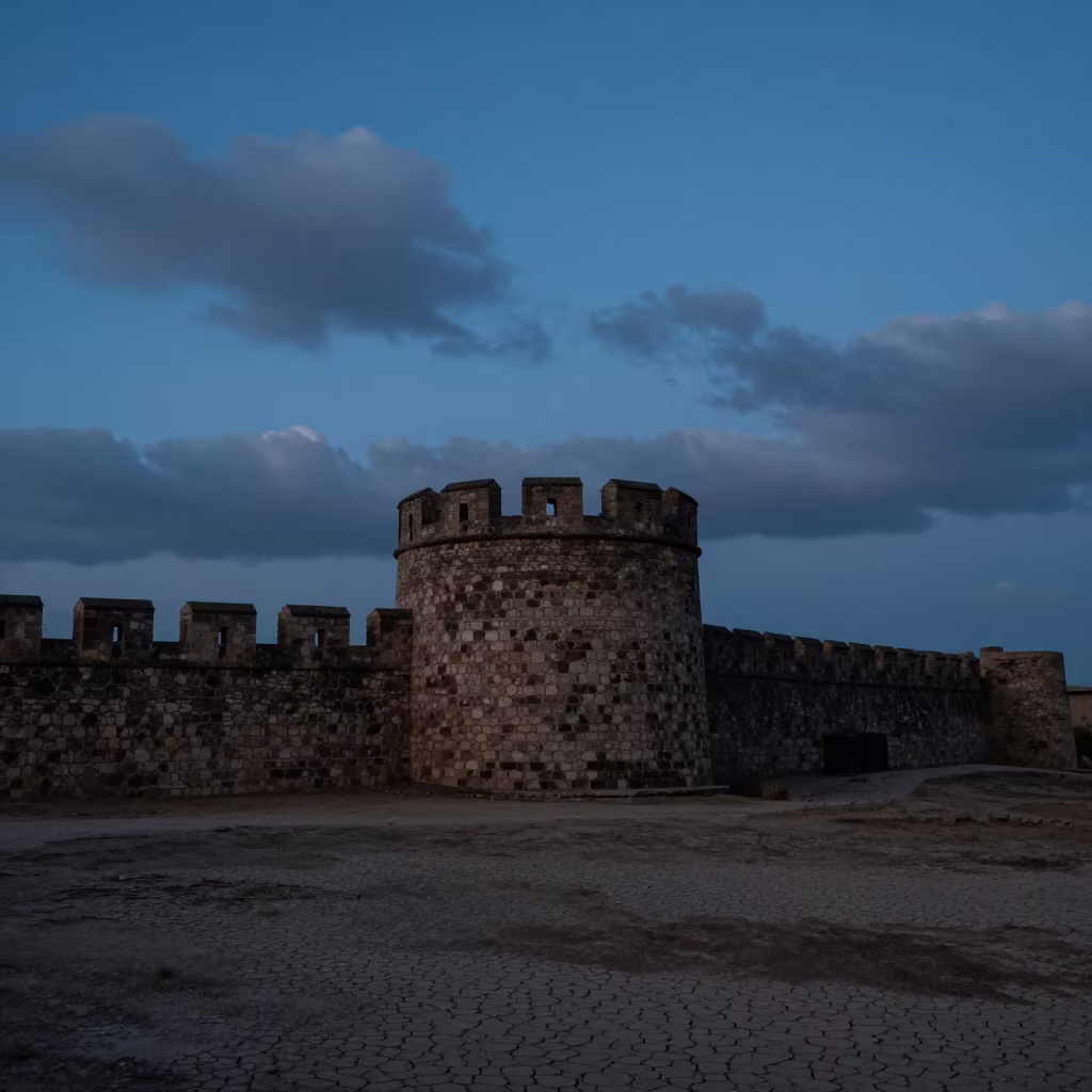 Silhouetted Stone Tower Against Blue Hour Sky in outside a wind-scoured fortress wall in Lijiang