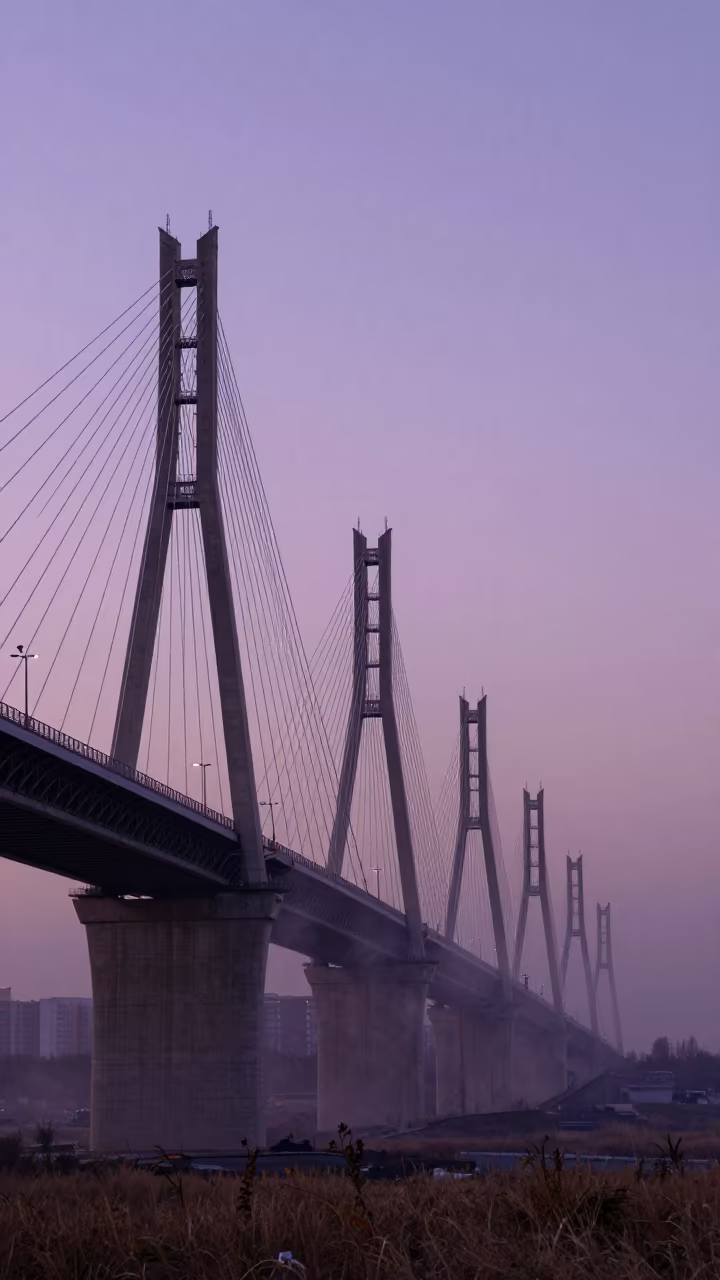 Silhouetted Transmission Towers on Bishkek Ridge at Twilight in under a cable-stayed bridge span in Bishkek