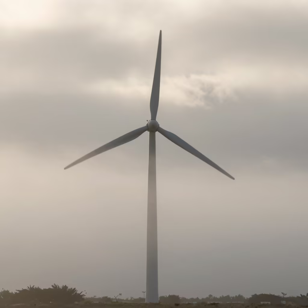 Silhouetted Wind Turbine in Morning Fog in over a horizon of stacked thunderheads in Bahamas