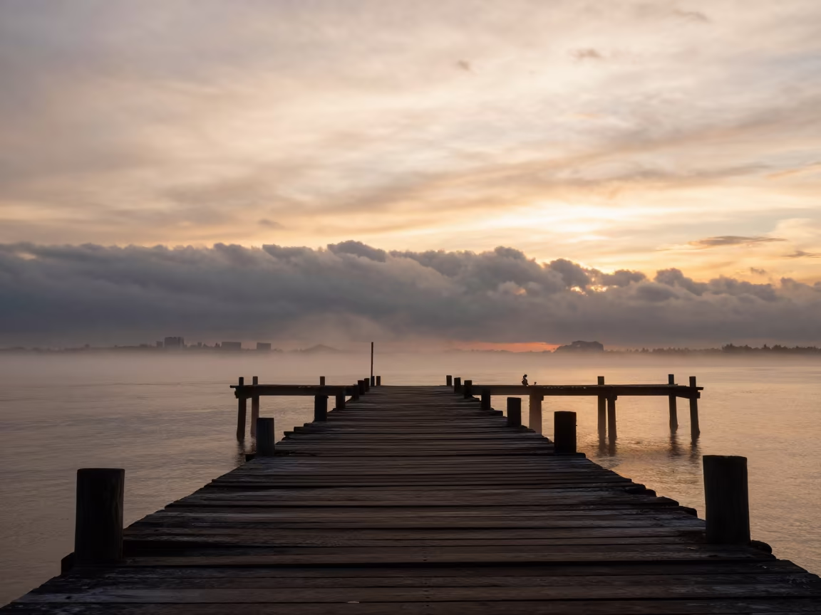 Silhouetted Wooden Pier Against Stormy Horizon at Golden Hour in over a horizon of stacked thunderheads near Quezon City