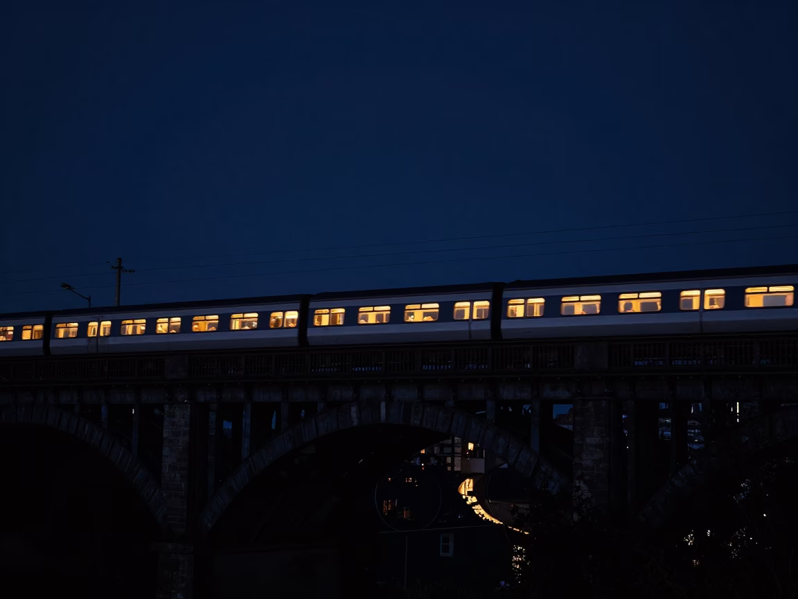Sleeper Train Lit Windows Crossing Dark Bridge in Edinburgh Under Deep Night Sky in in Edinburgh, United Kingdom