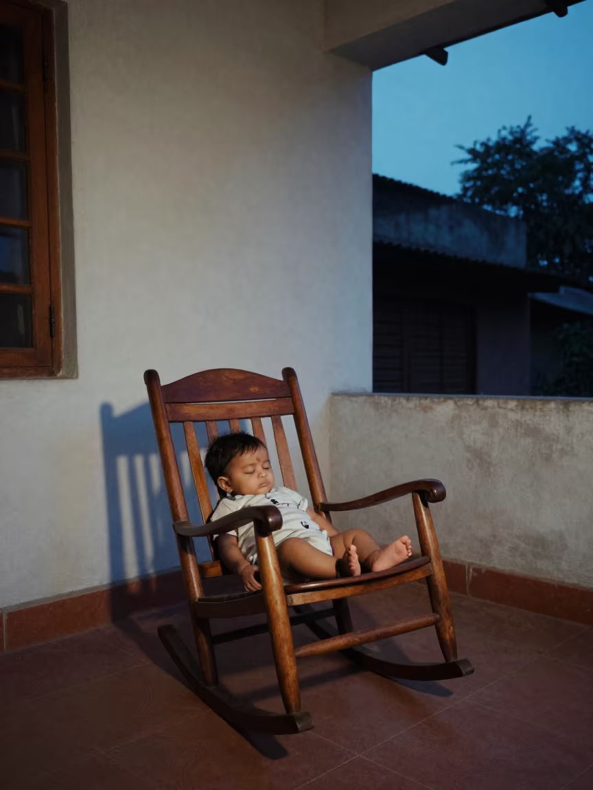 Sleeping Baby in Rocking Chair on Ulhasnagar Porch in on a porch with a rocking chair near Ulhasnagar