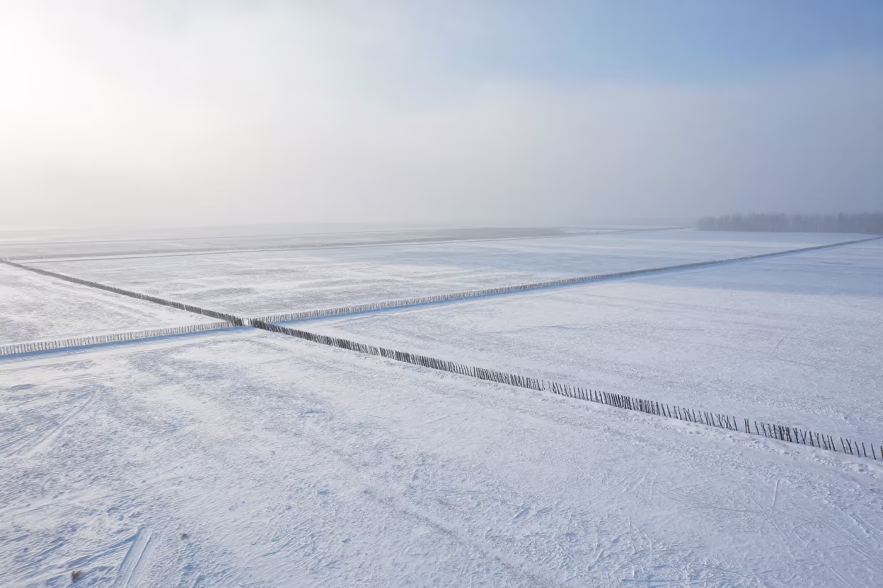 Snow Fences Across Hokkaido Prairie Mist in far above surf-scalloped coastline in Hokkaido