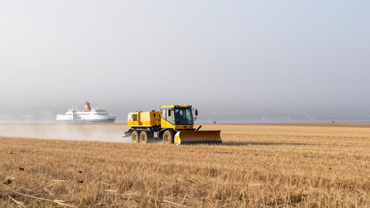 Snowplow Crossing Wheat Fields Summer Mist in across a remote ferry crossing near Oslo