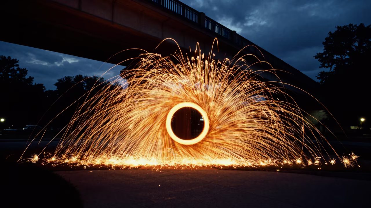 Spinning Steel Wool Sparks Under Bridge in across a formal civic plaza in North Carolina