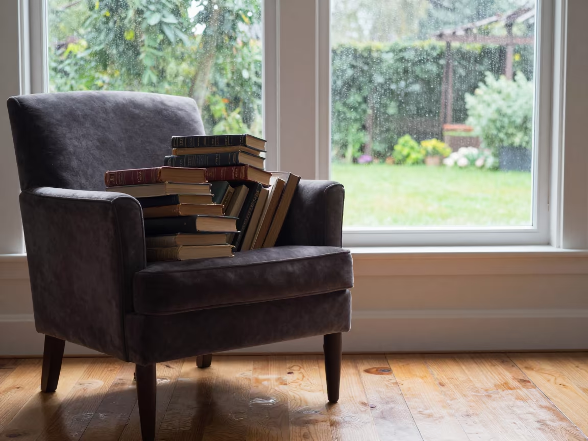 Stacked Library Books on Armchair Near Window in in a cozy kitchen near Larissa