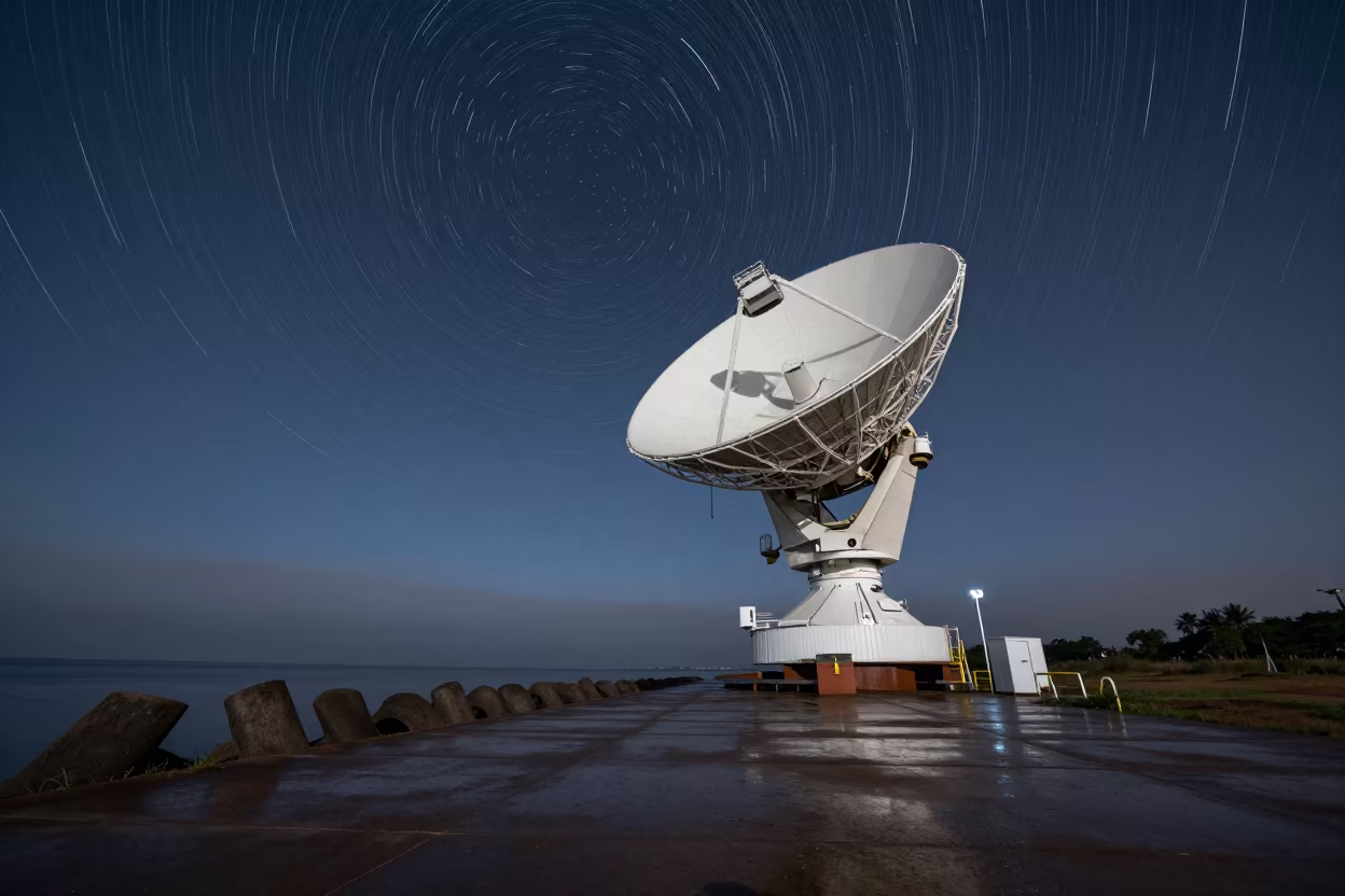 Star Trails Above Radio Dish on Moonlit Breakwater in from a moonlit breakwater in Paraguay