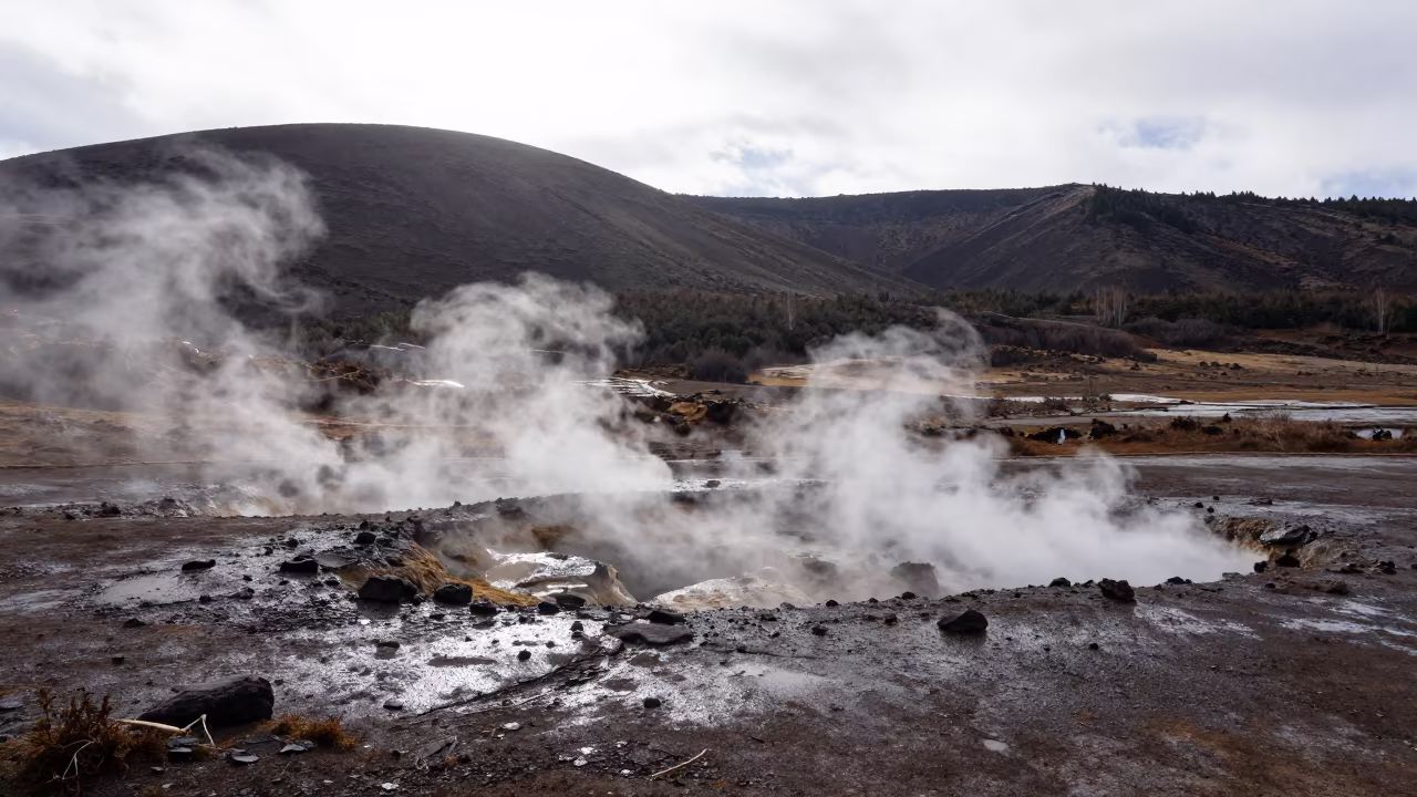 Steaming Fumaroles on Yunnan Volcanic Plateau in from a ridge above layered foothills in Yunnan