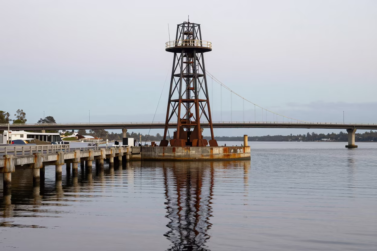 Steel Counterweight Tower Reflected in Harbor Oil in beside a bridge pier above moving water in Queensland