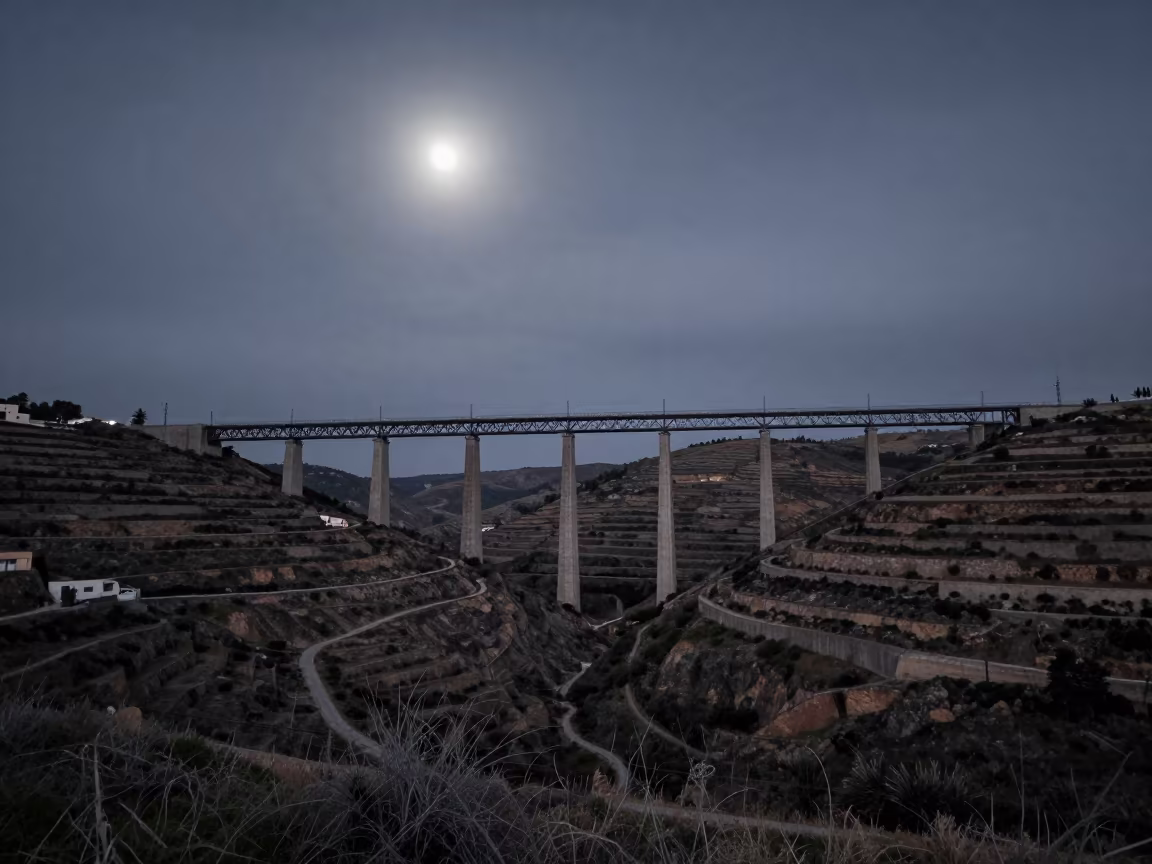Steel Viaduct Over Terraced Hills at Night in under a viaduct of steel and concrete near Tétouan