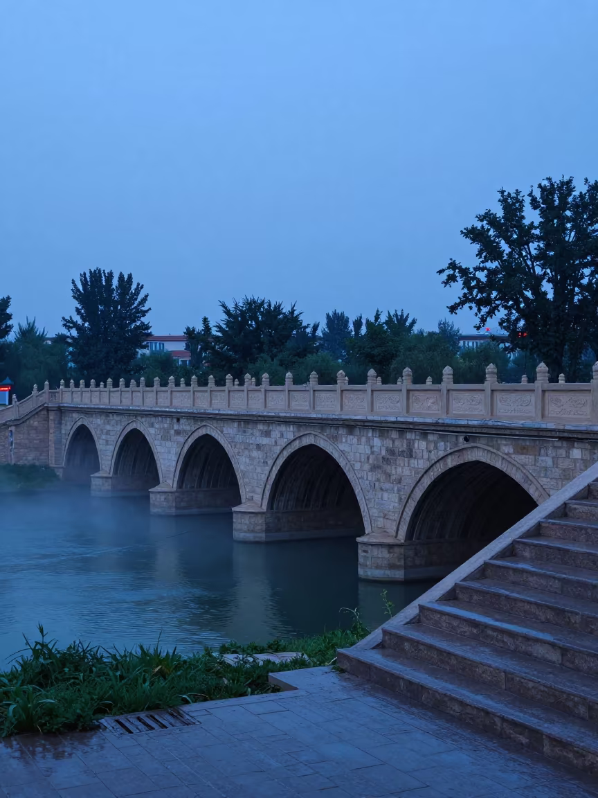 Five Arch Stone Bridge Over Misty River in Twilight in at the base of a monumental staircase near Urumqi
