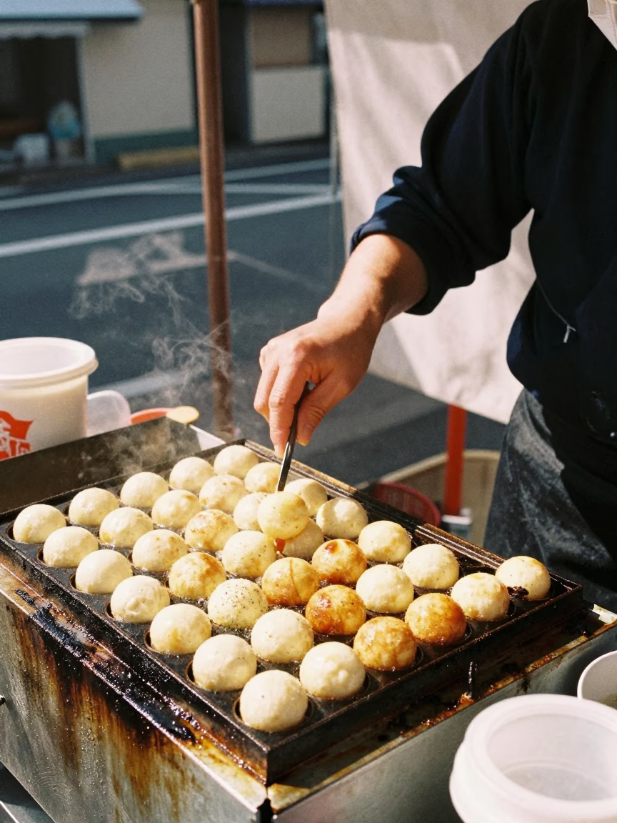 Street Vendor Cooking Takoyaki on Grill in Fukuoka Japan Midday Sun in in Fukuoka, Japan