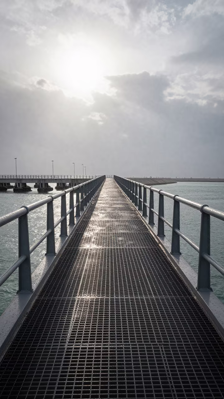 Striped Shadows on Bridge Walkway Noon Bahrain in beside a bridge pier above moving water in Bahrain