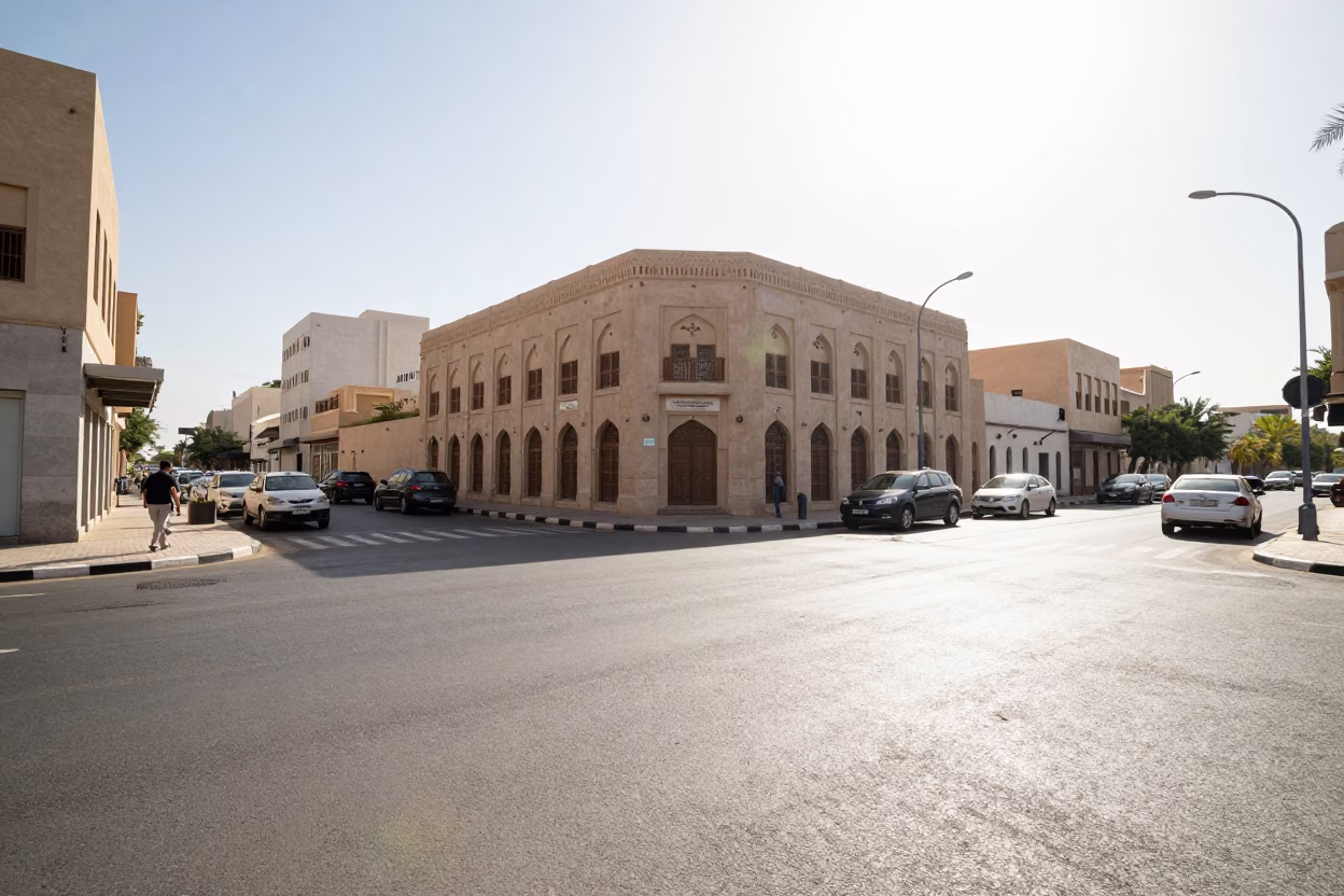 Sun-bleached Muscat street corner with traffic and traditional architecture under noon glare in in Muscat, Oman