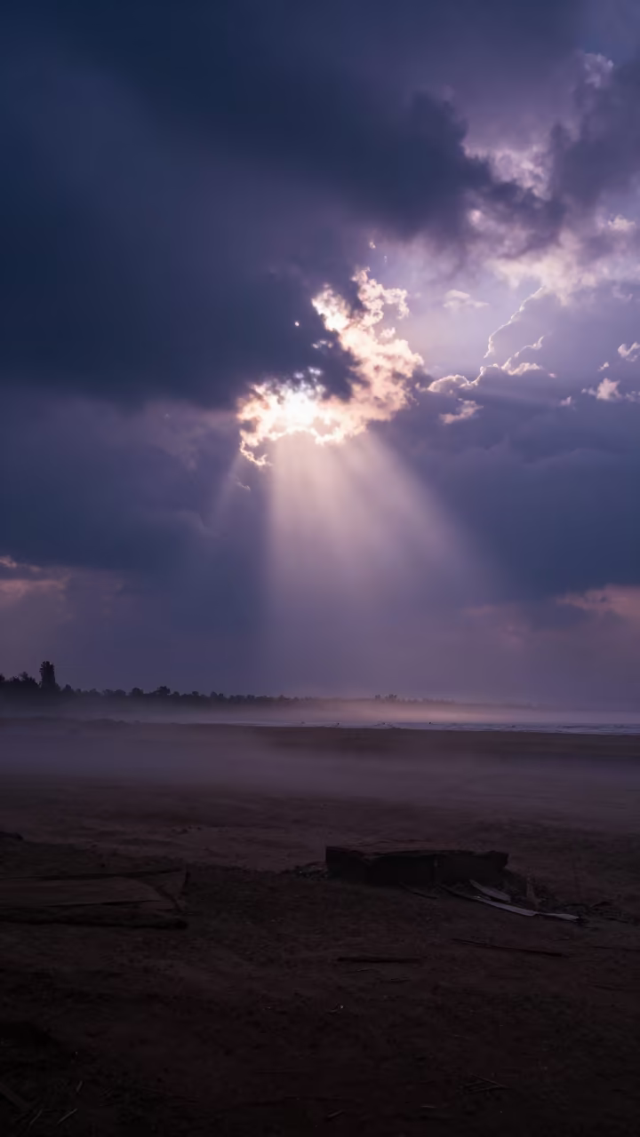 Sun Rays Piercing Storm Clouds Indigo Twilight in through low marine fog near Ado Ekiti