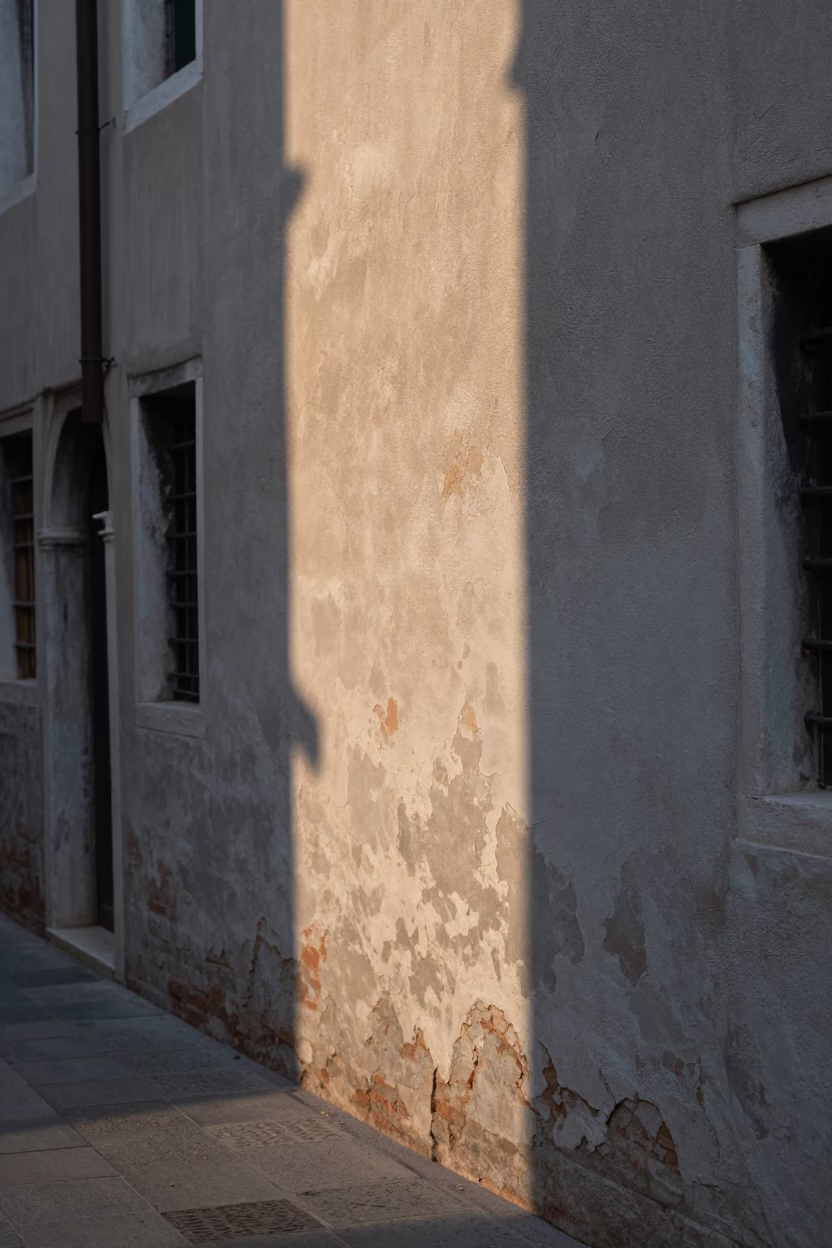Sunlight stripe on plaster wall in early morning Venice Italy canal scene in in Venice, Italy
