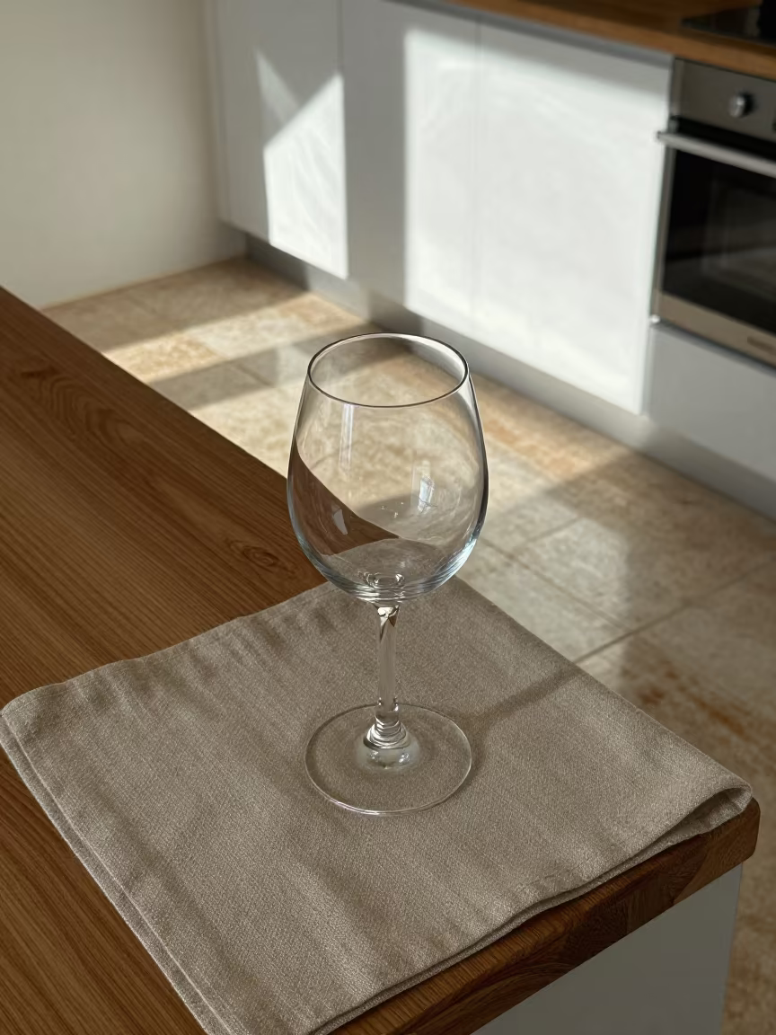 Sunlight through wine glass stem on linen in on a kitchen worktop in Old Medina, Casablanca