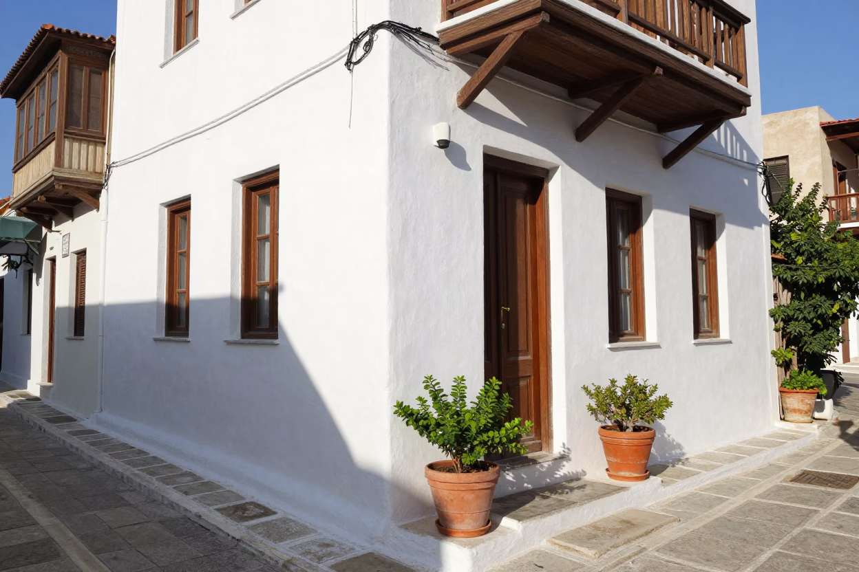 Sunlit Athens Street Scene with White Stucco Building and Potted Plants in in Athens, Greece