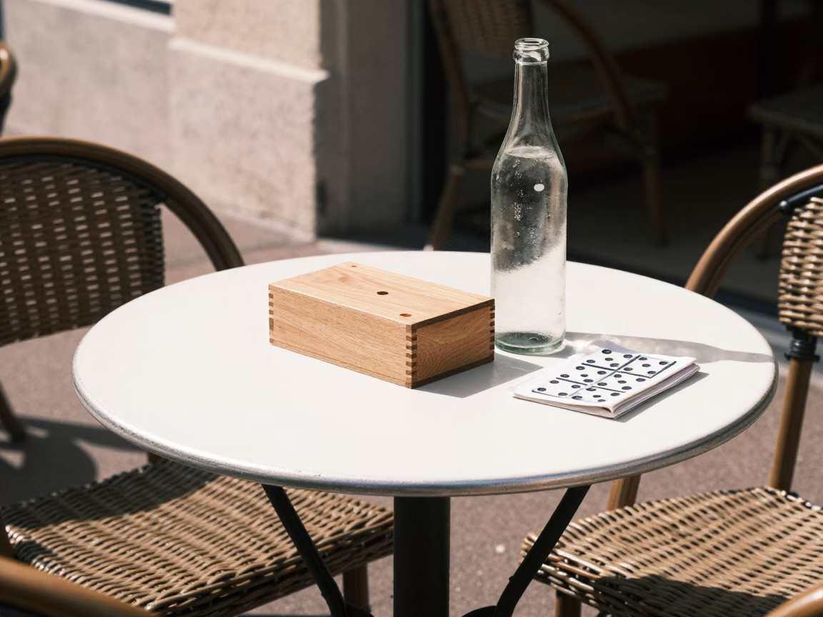 Sunlit Cafe Table in Nice France with Wicker Shadow and Domino Box in in Nice, France